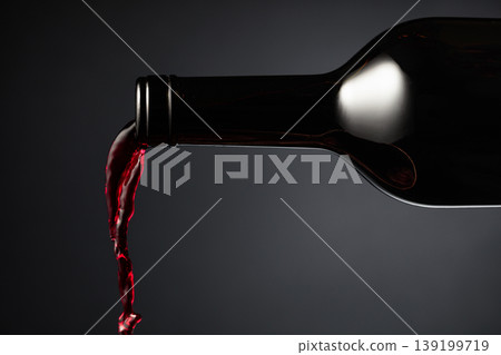 Red wine pours out of the bottle. Red wine pours out of the bottle. 139199719