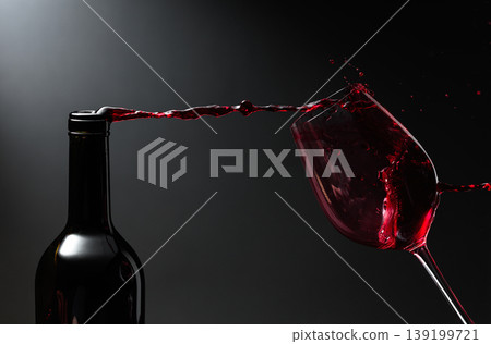 Red wine of rich color being poured from a bottle into a glass. Red wine of rich color being poured from a bottle into a glass. 139199721