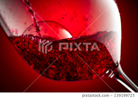 Red wine is poured into a glass. Red wine is poured into a glass. 139199725
