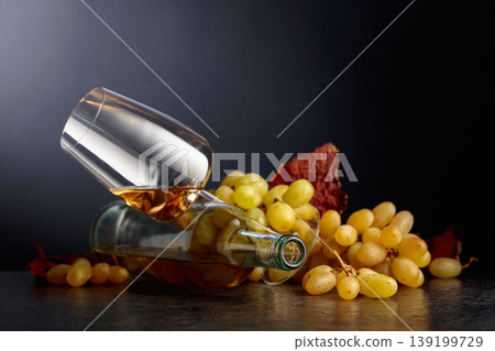 Grapes and white wine on a black background. Grapes and white wine on a black background. 139199729