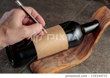 Man writes with a pencil on a blank label. Man writes with a pencil on a blank label. 139199735