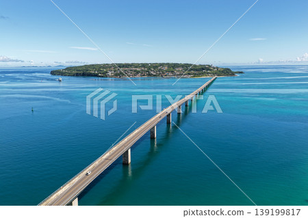 An August photograph taken from above, showing the Kouri Bridge and Kouri Island stretching across the emerald green sea in midsummer. An August photograph taken from above, showing the Kouri Bridge and Kouri Island stretching across the emerald green sea in midsummer. 139199817