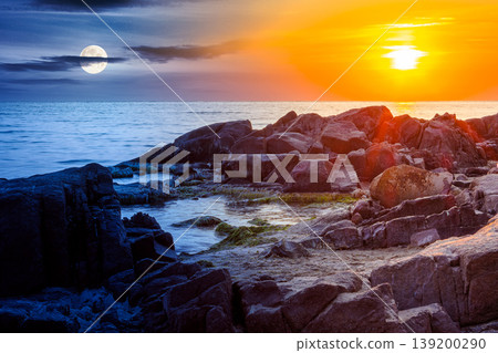 sea with rocky shore. day meet night. sun and moon over beautiful autumn equinox scenery and vacation concept on the rocky beach at twilight. scenic destination of seaside near old resort town sea with rocky shore. day meet night. sun and moon over beautiful autumn equinox scenery and vacation concept on the rocky beach at twilight. scenic destination of seaside near old resort town 139200290