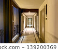 Elegant hotel corridor with Indian style design, warm lighting, and symmetrical hallway perspective. Interior architecture featuring doors, decorative arch, and luxury accommodation atmosphere 139200369