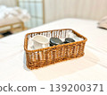 Hot stone massage set in woven basket with smooth basalt stones, towel, and ceramic bowl. Spa wellness concept for relaxation, therapy treatment, body care routine, and luxury beauty service setting 139200371