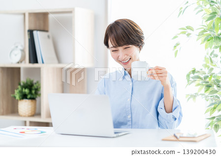 A middle-aged woman who teleworks in the living room. A middle-aged woman who teleworks in the living room. 139200430
