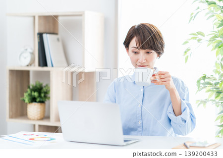 在客廳遠程辦公的中年婦女。 139200433