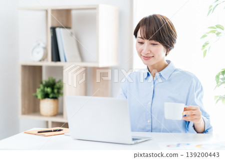 在客廳遠程辦公的中年婦女。 139200443
