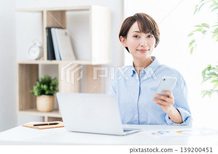 在客廳遠程辦公的中年婦女。 139200451