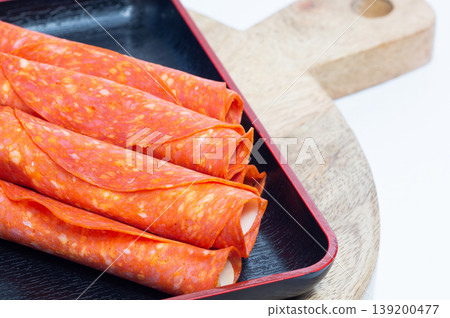 Pepperoni and Parmesan snacks lie on a wooden board. Pepperoni and Parmesan snacks lie on a wooden board. 139200477