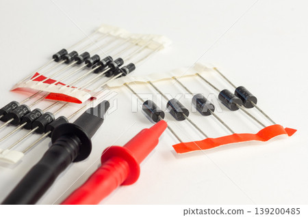 Multimeter with measurement probes and transistors on a white background 139200485