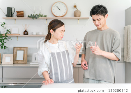 A young Asian couple having trouble with bad-tasting tap water in the kitchen A young Asian couple having trouble with bad-tasting tap water in the kitchen 139200542