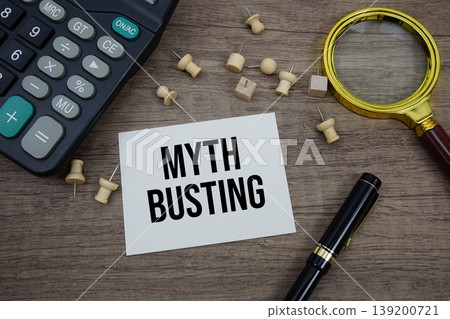 Myth Busting text written on notepad with pen, magnifying glass and calculator on wooden background 139200721