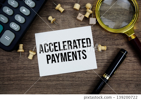 Accelerated Payments text written on notepad with pen, magnifying glass and calculator on wooden background Accelerated Payments text written on notepad with pen, magnifying glass and calculator on wooden background 139200722