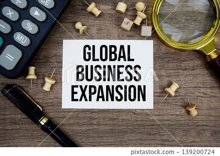Global Business Expansion text written on notepad with pen, magnifying glass and calculator on wooden background 139200724