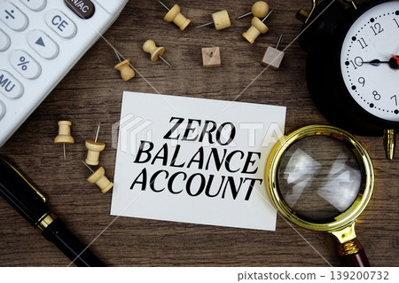 Zero Balance Account text written on notepad with pen, alarm clock, magnifying glass and calculator on wooden background Zero Balance Account text written on notepad with pen, alarm clock, magnifying glass and calculator on wooden background 139200732