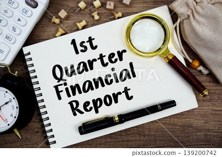 1st Quarter Financial Report text written on notepad with pen, alarm clock, magnifying glass and calculator on wooden background 139200742