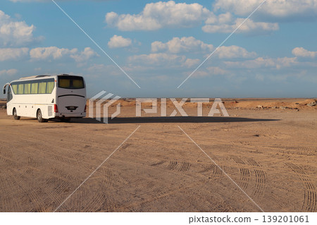 White bus traveling through empty desert landscape White bus traveling through empty desert landscape 139201061