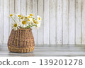 Happy birthday or mothers day greeting card template; bouquet of white daisy flowers in a wicker basket on a wooden background, copy space 139201278