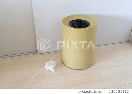 A tissue paper lying near the trash can A tissue paper lying near the trash can 139201512