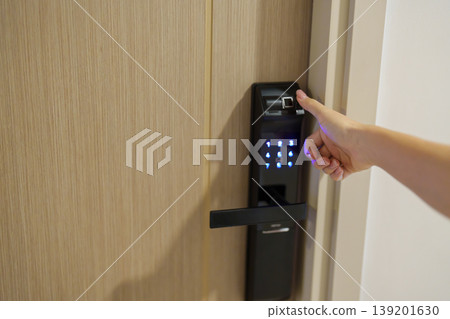 Hand using fingerprint scan for smart digital door lock while open or close the door at home or apartment. NFC Technology, keycard, PIN number, smartphone and contactless lifestyle concepts 139201630