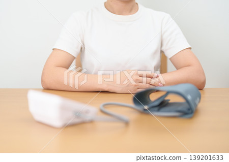 woman checking Blood pressure by Blood pressure monitor with Cuff. Systolic, SYS, Diastolic, DIA, Pulse, Hypertension, Hypotension, Heart rate, Cardiovascular Disease and May World hypertension day 139201633