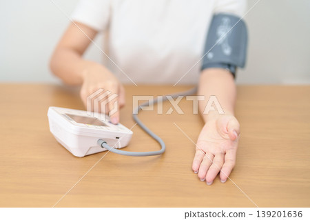 woman checking Blood pressure by Blood pressure monitor with Cuff. Systolic, SYS, Diastolic, DIA, Pulse, Hypertension, Hypotension, Heart rate, Cardiovascular Disease and May World hypertension day woman checking Blood pressure by Blood pressure monitor with Cuff. Systolic, SYS, Diastolic, DIA, Pulse, Hypertension, Hypotension, Heart rate, Cardiovascular Disease and May World hypertension day 139201636