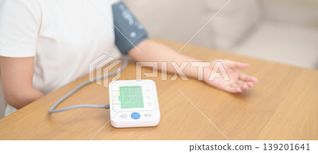 woman checking Blood pressure by Blood pressure monitor with Cuff. Systolic, SYS, Diastolic, DIA, Pulse, Hypertension, Hypotension, Heart rate, Cardiovascular Disease and May World hypertension day woman checking Blood pressure by Blood pressure monitor with Cuff. Systolic, SYS, Diastolic, DIA, Pulse, Hypertension, Hypotension, Heart rate, Cardiovascular Disease and May World hypertension day 139201641