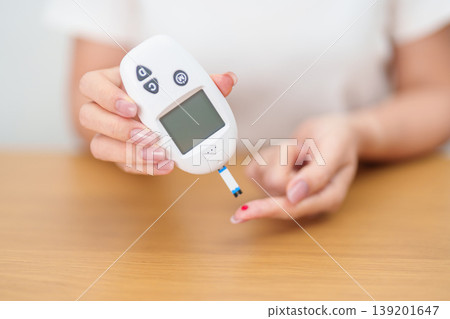 Hand checking Diabetes or Blood glucose self testing by digital blood glucose meter with lancet pen. high blood sugar level, World Diabetes Day, Glycemia, Hypoglycemia, Hyperglycemia and insulin Hand checking Diabetes or Blood glucose self testing by digital blood glucose meter with lancet pen. high blood sugar level, World Diabetes Day, Glycemia, Hypoglycemia, Hyperglycemia and insulin 139201647