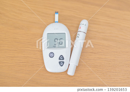 digital blood glucose meter with lancet pen on table. Diabetes checking or Blood glucose self testing, blood sugar level, World Diabetes Day, Glycemia, Hypoglycemia, Hyperglycemia and insulin digital blood glucose meter with lancet pen on table. Diabetes checking or Blood glucose self testing, blood sugar level, World Diabetes Day, Glycemia, Hypoglycemia, Hyperglycemia and insulin 139201653