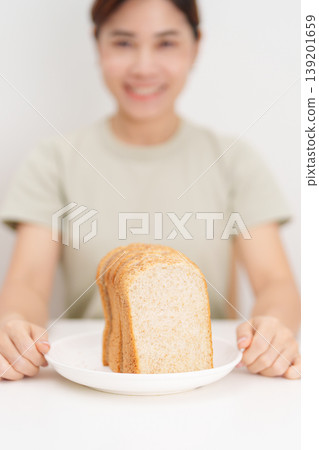Happy smiling woman with whole wheat bread. Weight loss management, Dieting, Healthy eating, Calorie control, Fitness food, High fiber, Wellness, Lifestyle, Metabolism and Glycemic Index Happy smiling woman with whole wheat bread. Weight loss management, Dieting, Healthy eating, Calorie control, Fitness food, High fiber, Wellness, Lifestyle, Metabolism and Glycemic Index 139201659