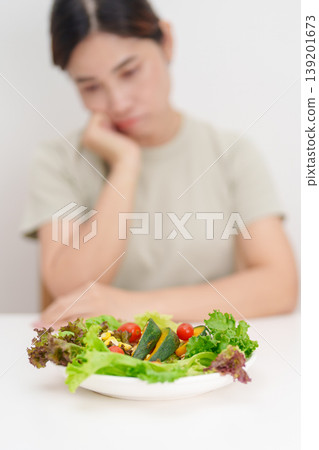 Unhappy woman disgust gesture and Bored to eat fresh organic vegetables. healthy nutrition, weight loss, clean eating, Healthy food eating, Vegan, Wellness, Green dieting and Healthy lifestyle Unhappy woman disgust gesture and Bored to eat fresh organic vegetables. healthy nutrition, weight loss, clean eating, Healthy food eating, Vegan, Wellness, Green dieting and Healthy lifestyle 139201673