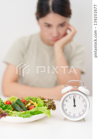 hungry woman with fresh organic vegetables plate and clock. intermittent fasting, IF, time to eating, nutrition control, weight loss, clean eating, Healthy food eating, Wellness, dieting and lifestyle hungry woman with fresh organic vegetables plate and clock. intermittent fasting, IF, time to eating, nutrition control, weight loss, clean eating, Healthy food eating, Wellness, dieting and lifestyle 139201677