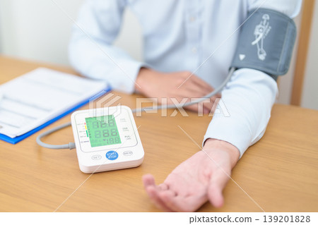 Man checking Blood pressure by Blood pressure monitor with Cuff. Systolic, SYS, Diastolic, DIA, Pulse, Hypertension, Hypotension, Heart rate, Cardiovascular Disease and May World hypertension day 139201828