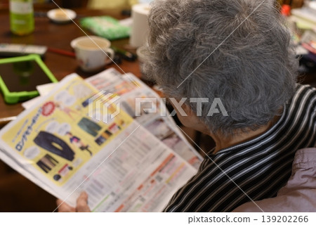 Senior woman looking at flyer Senior woman looking at flyer 139202266