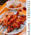 Japanese izakaya menu: Yakitori (grilled chicken skewers) and motsu nikomi (stewed offal). 139202322