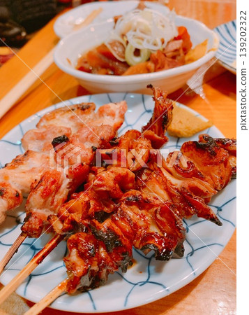 Japanese izakaya menu: Yakitori (grilled chicken skewers) and motsu nikomi (stewed offal). Japanese izakaya menu: Yakitori (grilled chicken skewers) and motsu nikomi (stewed offal). 139202322