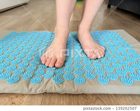 The children's feet stand on a Tibetan rug, needle-knitted. 139202507