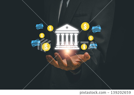 Businessman holding digital banking icons, symbolizing fintech and online transactions, in a modern business setting. Businessman holding digital banking icons, symbolizing fintech and online transactions, in a modern business setting. 139202659