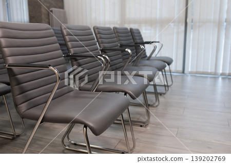 Side perspective of stylish gray conference chairs in modern business meeting room interior Side perspective of stylish gray conference chairs in modern business meeting room interior 139202769
