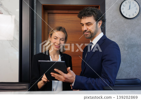 Business Team Using Digital Tablet Together at Modern Reception Desk Office Interior 139202869