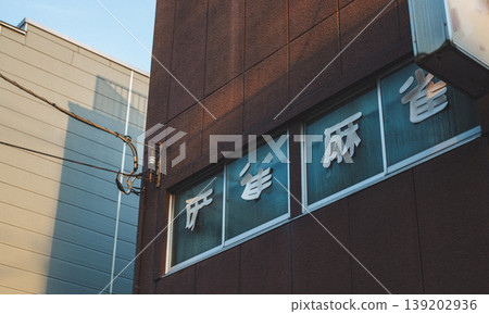 建築物的外部,麻將館歇業的招牌仍然清晰可見,窗戶和字跡也清晰可見。 建築物的外部,麻將館歇業的招牌仍然清晰可見,窗戶和字跡也清晰可見。 139202936