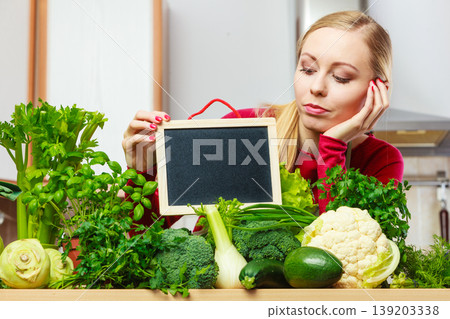 Woman having green vegetables holding board Woman having green vegetables holding board 139203338