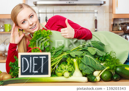 Woman in kitchen having green diet vegetables 139203343