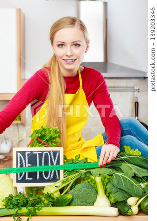 Woman having green diet vegetables, detox sign 139203346