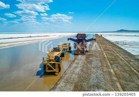 Aerial view captures heavy machinery operates on Lake Baskunchak extracting salt during a clear day mining operation 139203405
