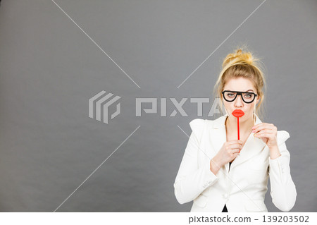 Happy elegant woman holding carnival accessoies on stick Happy elegant woman holding carnival accessoies on stick 139203502