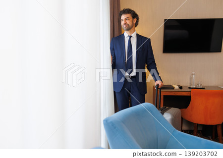 Professional Traveler In Hotel Room Near Desk And Window Professional Traveler In Hotel Room Near Desk And Window 139203702