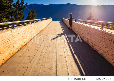 Tourist enjoying fjord view on Stegastein viewpoint Norway Tourist enjoying fjord view on Stegastein viewpoint Norway 139203798