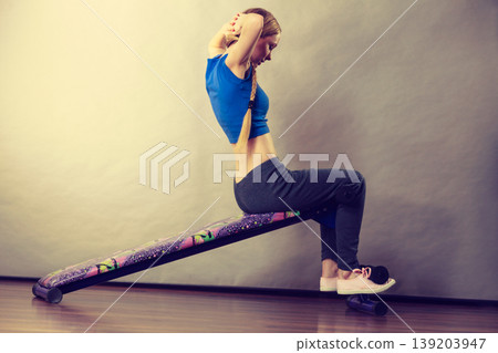 Woman training on bench for sit ups Woman training on bench for sit ups 139203947